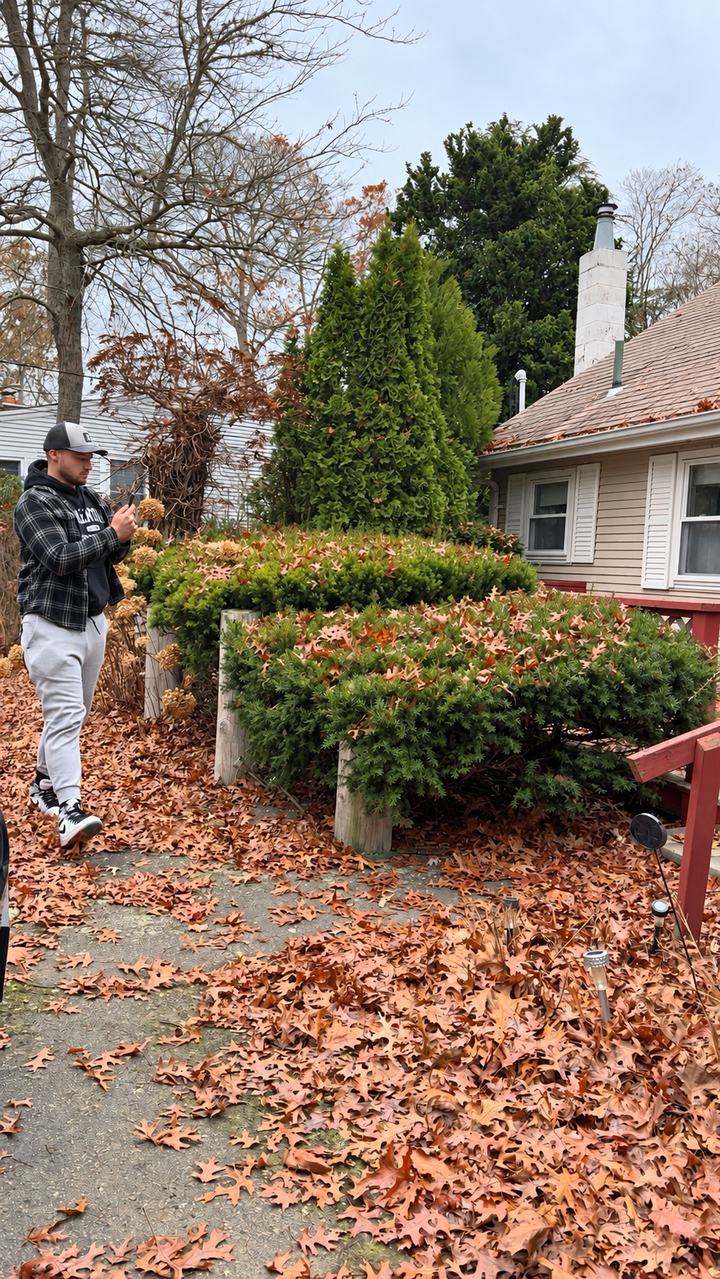Greg Valentgas photographing the yard and side of a home in East Falmouth on a fall day